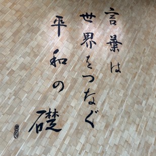 キャンパスに掲げられた「言葉は世界をつなぐ平和の礎」の書